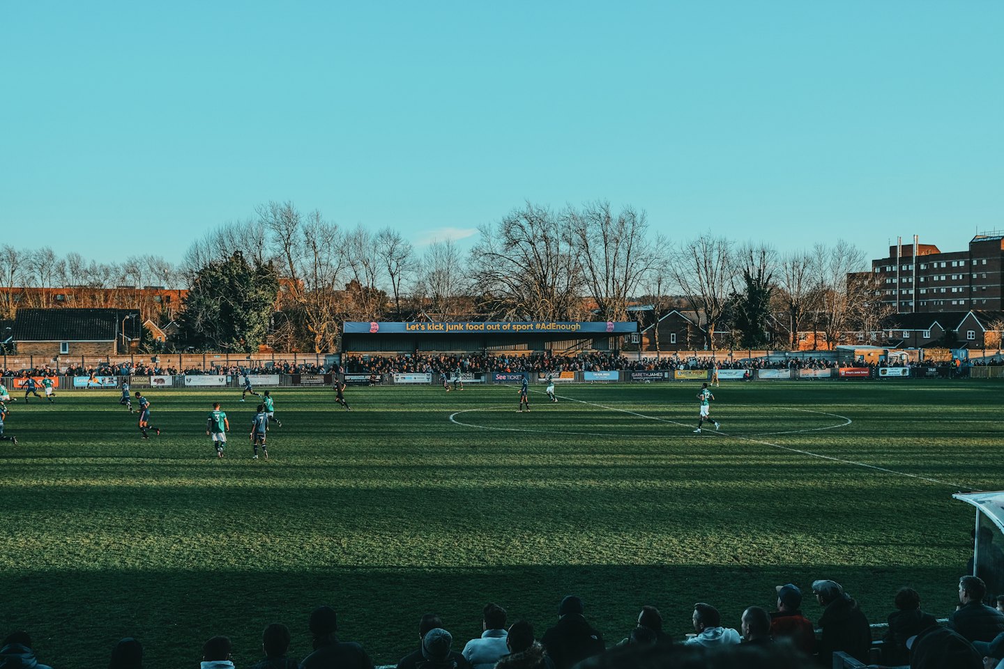 Soccer players compete on a sunny outdoor field.